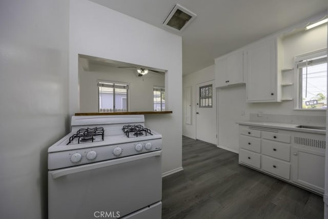 2292 Euclid Ave, Long Beach, CA 90815 - kitchen with gas range gas stove, white cabinetry, dark wood finished floors, light countertops, and baseboards