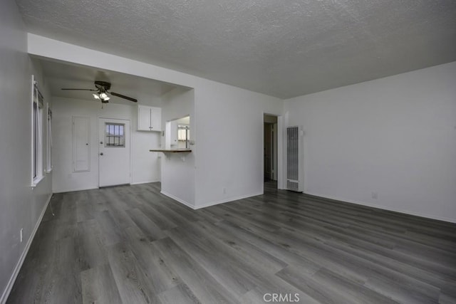 2292 Euclid Ave, Long Beach, CA 90815 - unfurnished living room featuring a heating unit, dark wood-style flooring, a textured ceiling, a ceiling fan, and baseboards