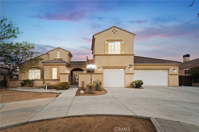 17830 Mana Rd, Apple Valley, CA 92307 - mediterranean / spanish-style house with a tile roof, stucco siding, concrete driveway, a gate, and a garage