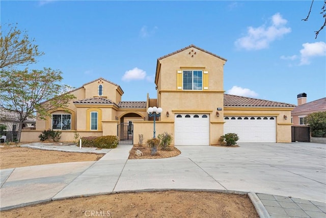 17830 Mana Rd, Apple Valley, CA 92307 - mediterranean / spanish-style home featuring stucco siding, a tiled roof, concrete driveway, and a gate