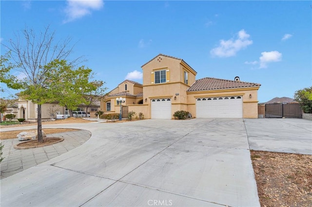 17830 Mana Rd, Apple Valley, CA 92307 - mediterranean / spanish-style house with stucco siding, concrete driveway, a tiled roof, and a gate