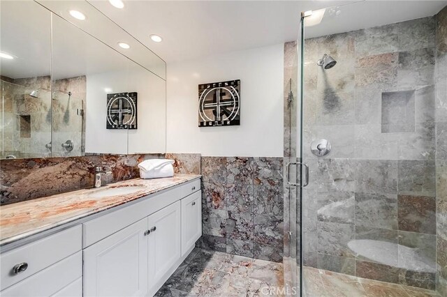 4820 Encino Ter, Encino, CA 91316 - bathroom with vanity, marble look tiles, a stall shower, tile walls, and recessed lighting