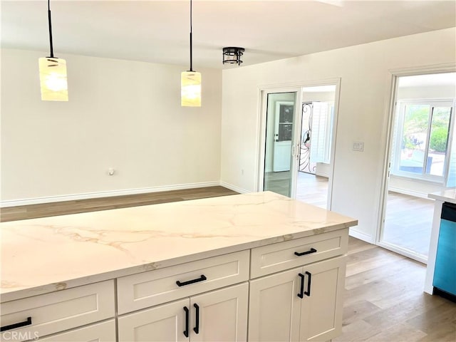 29041 Desert Hills Rd, Menifee, CA 92586 - kitchen with light wood-style flooring, hanging light fixtures, and light stone countertops