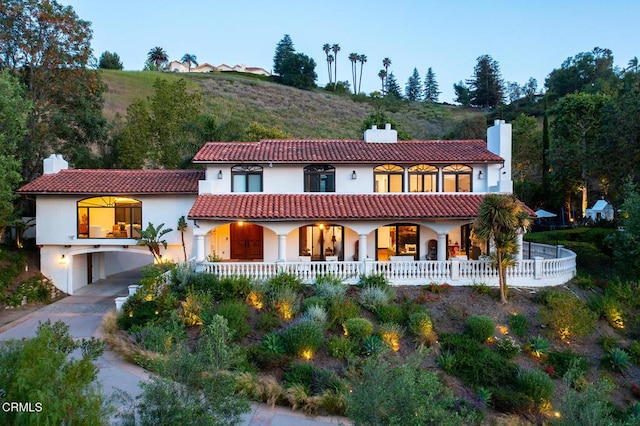 4548 Valley Spring Dr, Westlake Village, CA 91362 - mediterranean / spanish-style home featuring a chimney, a porch, stucco siding, and a carport