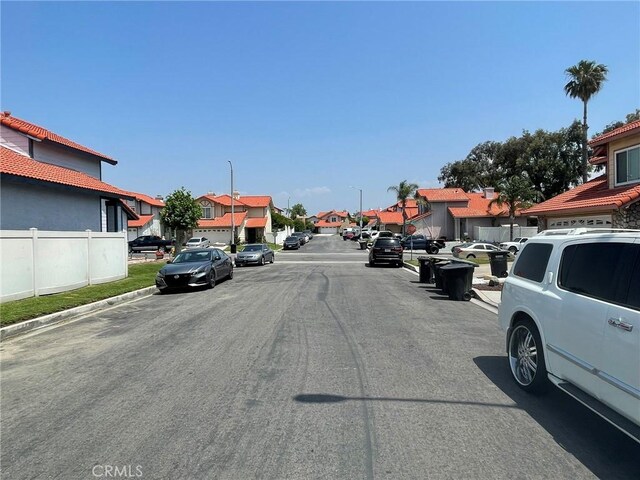 1186 Runaway Cir, Colton, CA 92324 - view of asphalt road with a residential view, street lights, and curbs