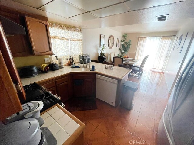1186 Runaway Cir, Colton, CA 92324 - kitchen featuring tile countertops, dishwasher, a peninsula, and light tile patterned floors