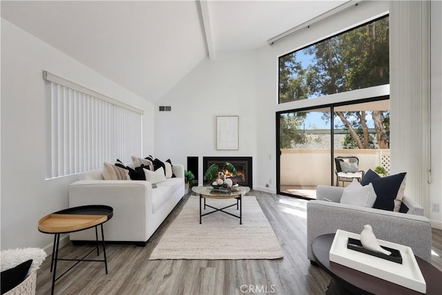 190 N Singingwood St Unit 1, Orange, CA 92869 - living area with beam ceiling, high vaulted ceiling, wood finished floors, and a glass covered fireplace