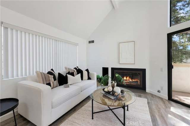 190 N Singingwood St Unit 1, Orange, CA 92869 - living area featuring high vaulted ceiling, wood finished floors, a glass covered fireplace, and beam ceiling