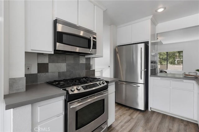 190 N Singingwood St Unit 1, Orange, CA 92869 - kitchen featuring appliances with stainless steel finishes, decorative backsplash, white cabinetry, light wood-style flooring, and recessed lighting