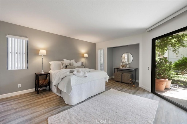 190 N Singingwood St Unit 1, Orange, CA 92869 - bedroom with access to exterior, multiple windows, and light wood-type flooring