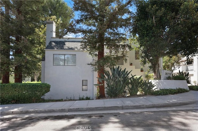 190 N Singingwood St Unit 1, Orange, CA 92869 - view of property exterior with stucco siding and a chimney