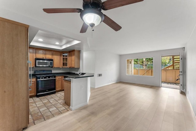 12590 Carmel Creek Rd Unit 1, San Diego, CA 92130 - kitchen featuring stainless steel microwave, range with gas cooktop, dark countertops, a tray ceiling, and open floor plan