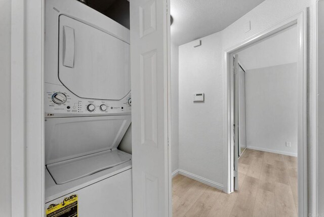 12590 Carmel Creek Rd Unit 1, San Diego, CA 92130 - washroom with stacked washer / drying machine and light wood-style floors