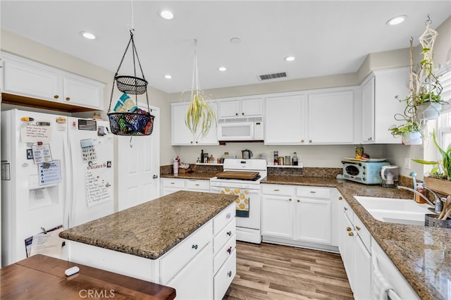5 Quartz Ln, Ladera Ranch, CA 92694 - kitchen with white appliances, white cabinets, light wood finished floors, dark stone counters, and recessed lighting