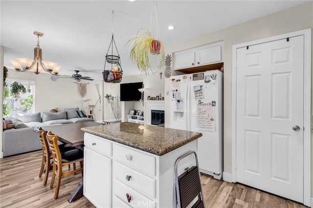 5 Quartz Ln, Ladera Ranch, CA 92694 - kitchen featuring white refrigerator with ice dispenser, a chandelier, light wood finished floors, white cabinetry, and a kitchen island