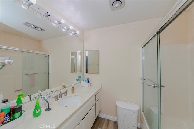 22224 S Vermont Ave Unit 102C, Torrance, CA 90502 - full bathroom featuring a shower with shower door, vanity, and wood finished floors