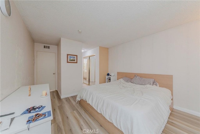 22224 S Vermont Ave Unit 102C, Torrance, CA 90502 - bedroom with light wood-type flooring, a closet, and a textured ceiling