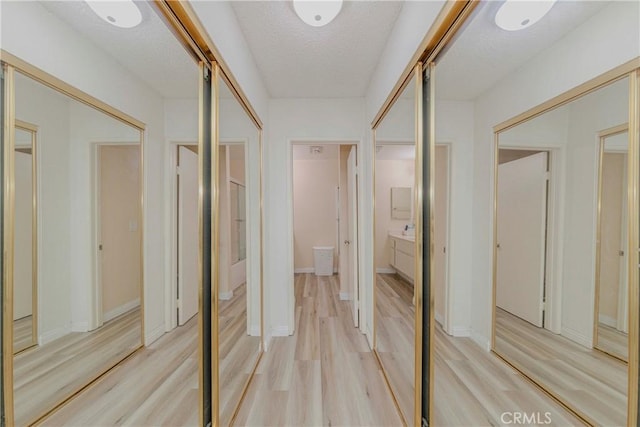 22224 S Vermont Ave Unit 102C, Torrance, CA 90502 - hall featuring light wood-style floors and a textured ceiling