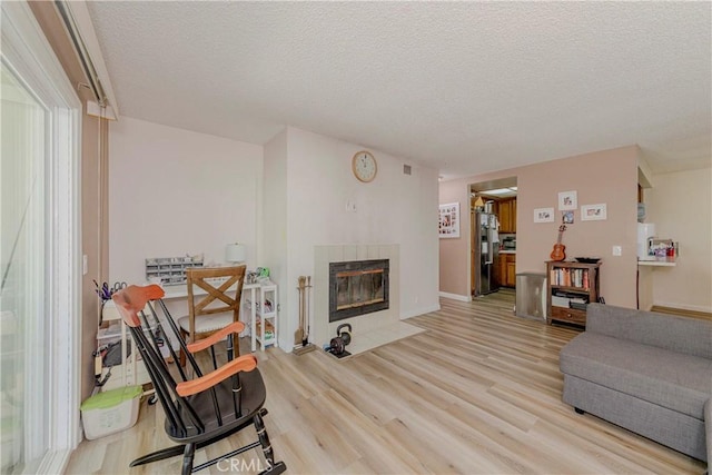 22224 S Vermont Ave Unit 102C, Torrance, CA 90502 - living room with a textured ceiling, a tile fireplace, and wood finished floors