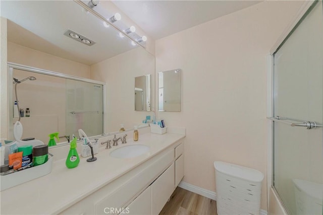 22224 S Vermont Ave Unit 102C, Torrance, CA 90502 - bathroom featuring vanity, wood finished floors, and shower / bath combination with glass door