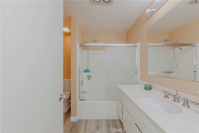 22224 S Vermont Ave Unit 102C, Torrance, CA 90502 - full bath featuring vanity, wood finished floors, shower / bath combination with glass door, and a textured ceiling