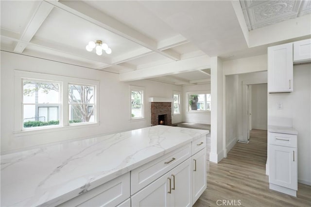 4415 12th St, Riverside, CA 92501 - kitchen featuring coffered ceiling, light wood-type flooring, light stone counters, white cabinets, and beamed ceiling