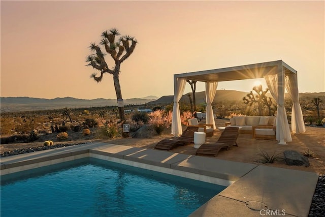 59425 Sun Mesa Rd, Yucca Valley, CA 92284 - pool at dusk with an outdoor hangout area, a mountain view, an outdoor pool, a patio area, and a gazebo