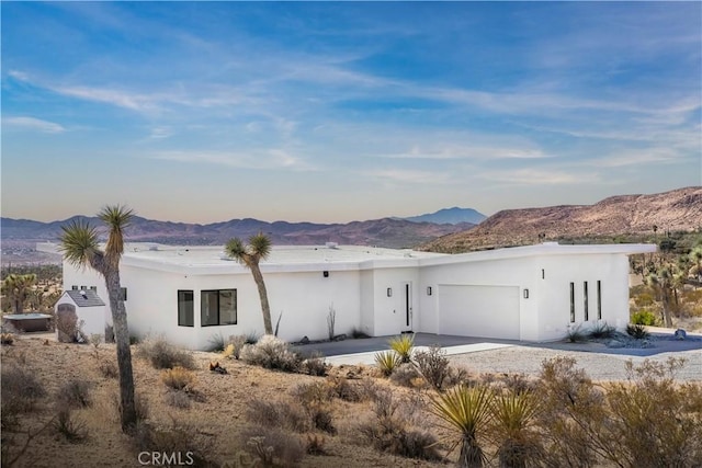 59425 Sun Mesa Rd, Yucca Valley, CA 92284 - view of front of house with an attached garage, a mountain view, stucco siding, and concrete driveway