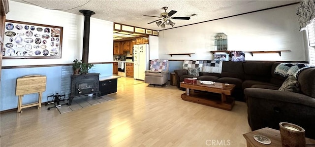 950 Cedar St, Corona, CA 92879 - living room with a wood stove, a ceiling fan, light wood-type flooring, and a textured ceiling