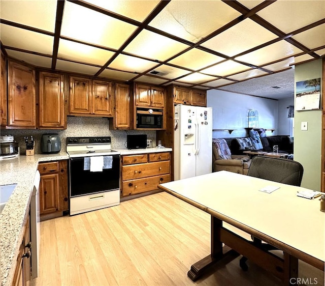 950 Cedar St, Corona, CA 92879 - kitchen featuring white appliances, light wood finished floors, tasteful backsplash, open floor plan, and brown cabinets