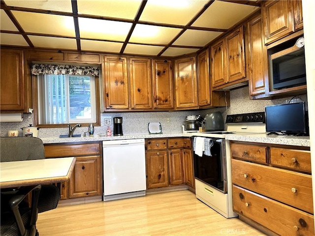 950 Cedar St, Corona, CA 92879 - kitchen featuring white appliances, a sink, brown cabinetry, light wood-style floors, and backsplash