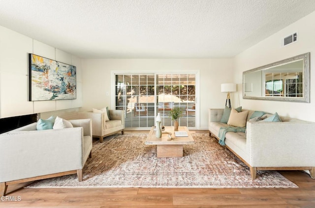 815 Perry Ave, Montebello, CA 90640 - living room featuring wood finished floors, healthy amount of natural light, and a textured ceiling