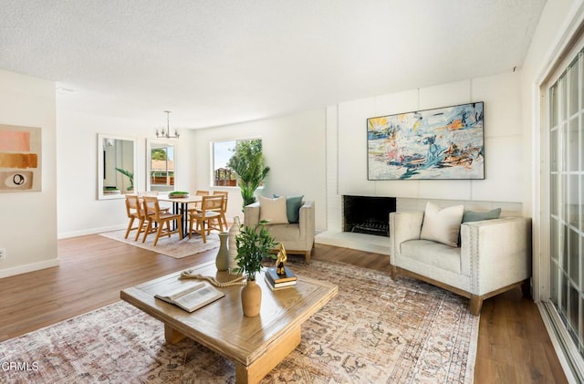 815 Perry Ave, Montebello, CA 90640 - living room featuring wood finished floors, baseboards, a chandelier, and a textured ceiling