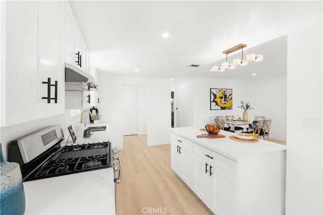 430 N Ellen Dr, West Covina, CA 91790 - kitchen featuring under cabinet range hood, stainless steel gas stove, light wood-style floors, recessed lighting, and white cabinetry