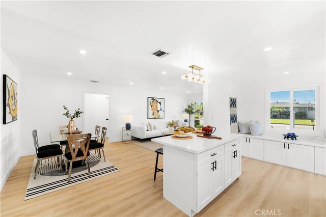 430 N Ellen Dr, West Covina, CA 91790 - kitchen with light wood-style flooring, white cabinetry, light countertops, recessed lighting, and a center island
