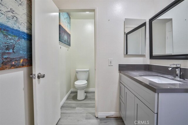 11112 Camellia Ave, Fountain Valley, CA 92708 - bathroom featuring vanity, wood finished floors, toilet, and baseboards