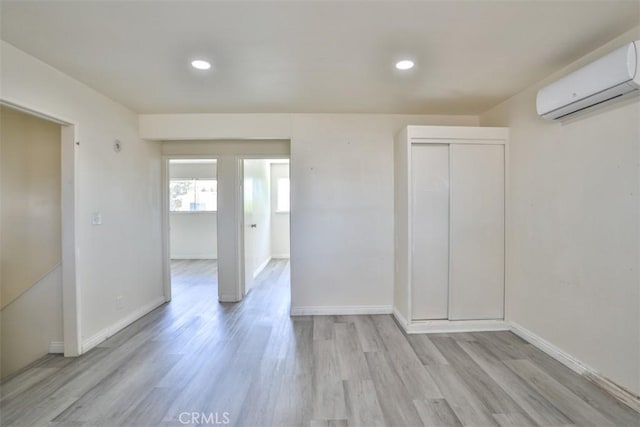 11112 Camellia Ave, Fountain Valley, CA 92708 - unfurnished room featuring an AC wall unit, light wood-style floors, baseboards, and recessed lighting