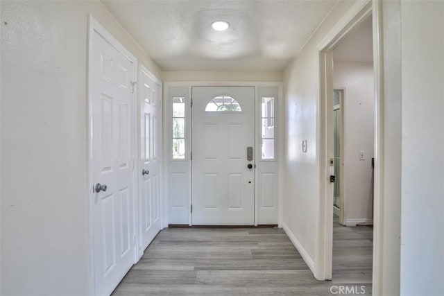 11112 Camellia Ave, Fountain Valley, CA 92708 - entrance foyer with light wood-style flooring, baseboards, and a textured ceiling