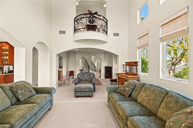 43845 Calle De Velardo, Temecula, CA 92592 - living room featuring light colored carpet, arched walkways, and a high ceiling