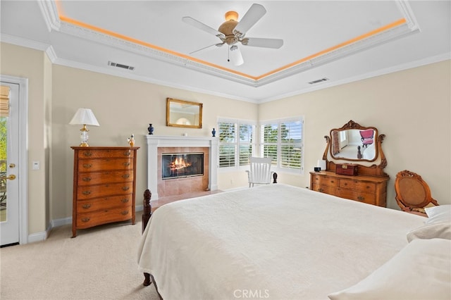 43845 Calle De Velardo, Temecula, CA 92592 - bedroom featuring a raised ceiling, crown molding, light carpet, a tiled fireplace, and a ceiling fan