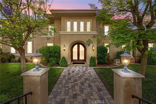 43845 Calle De Velardo, Temecula, CA 92592 - view of exterior entry with french doors, stucco siding, and a lawn