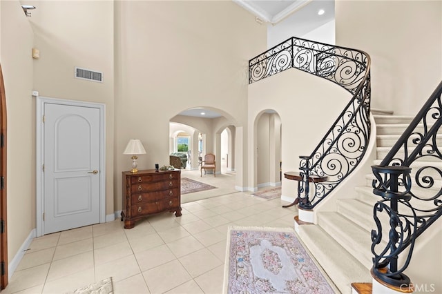 43845 Calle De Velardo, Temecula, CA 92592 - tiled foyer entrance featuring arched walkways, a towering ceiling, crown molding, and stairs