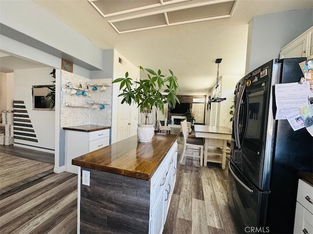 12477 Redrock Ct, Victorville, CA 92392 - kitchen with freestanding refrigerator, butcher block countertops, dark wood-style flooring, white cabinets, and hanging light fixtures