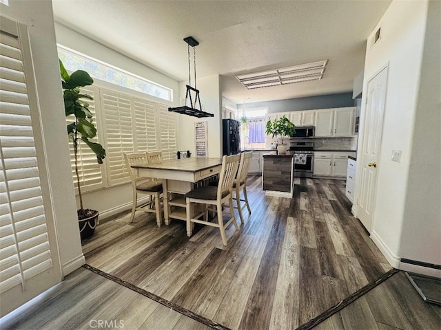12477 Redrock Ct, Victorville, CA 92392 - dining room featuring dark wood finished floors, plenty of natural light, and baseboards