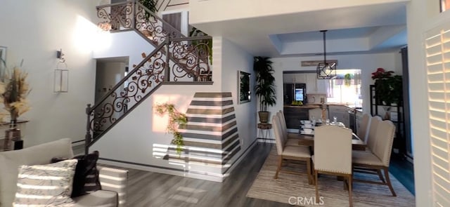 12477 Redrock Ct, Victorville, CA 92392 - dining room with stairway, wood finished floors, a tray ceiling, and baseboards