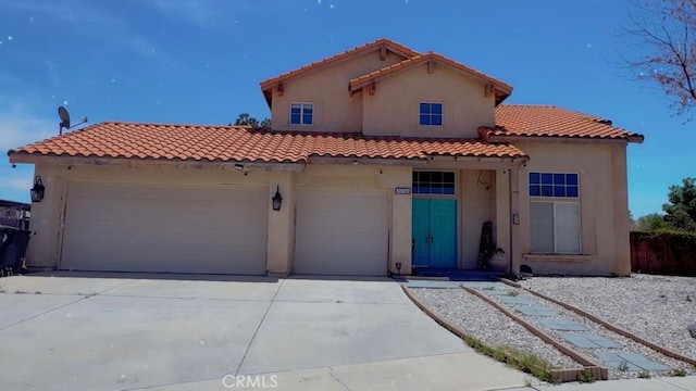 12477 Redrock Ct, Victorville, CA 92392 - mediterranean / spanish home featuring concrete driveway, a tile roof, stucco siding, and an attached garage