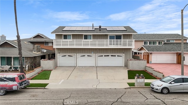 4941 Catamaran St, Oxnard, CA 93035 - multi unit property with a balcony, a garage, roof mounted solar panels, concrete driveway, and roof with shingles