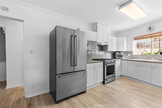 5741 Tobias Ave, Sherman Oaks, CA 91411 - kitchen featuring high end appliances, under cabinet range hood, backsplash, ornamental molding, and white cabinets
