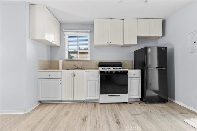 5741 Tobias Ave, Sherman Oaks, CA 91411 - kitchen with freestanding refrigerator, white gas range, a sink, and light wood-type flooring