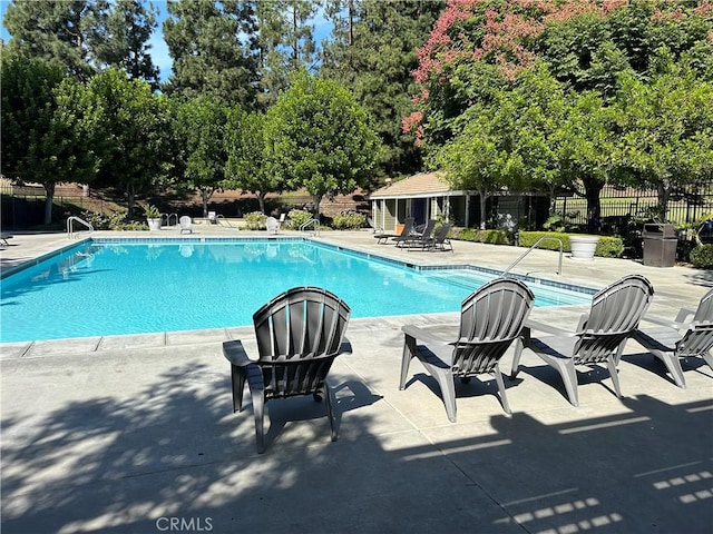 16521 Stonehaven Ct Unit 76, La Mirada, CA 90638 - community pool featuring a patio and view of wooded area